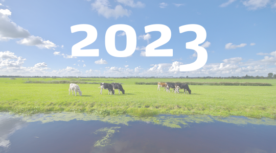 Tractor met kunstmeststrooier op grasland